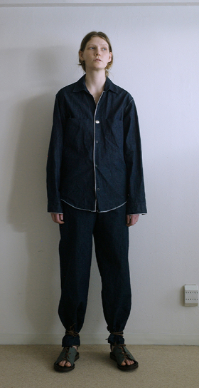 A person wearing a zip up black jacket and matching pants by SUNSEA