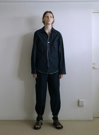 A person wearing a zip up black jacket and matching pants by SUNSEA