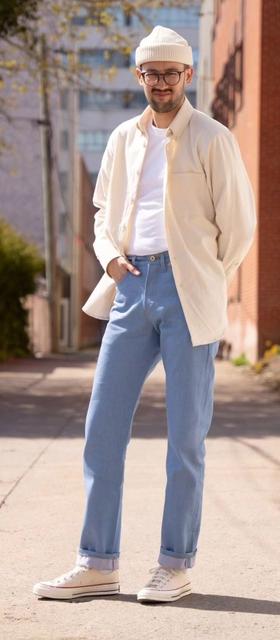 A man wearing Naked & Famous blue jeans and cream button up