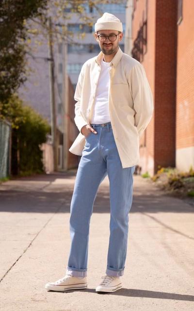 A man wearing Naked & Famous blue jeans and cream button up