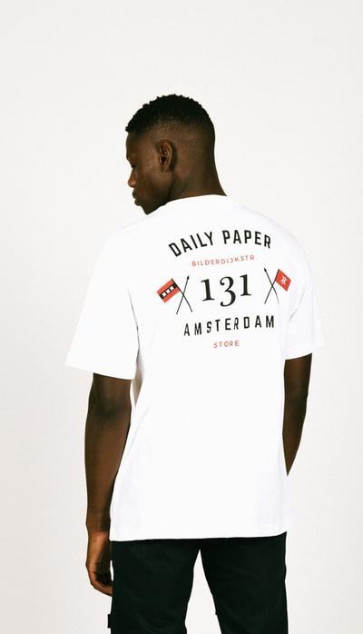 A man wearing a Daily Paper Amsterdam white t-shirt
