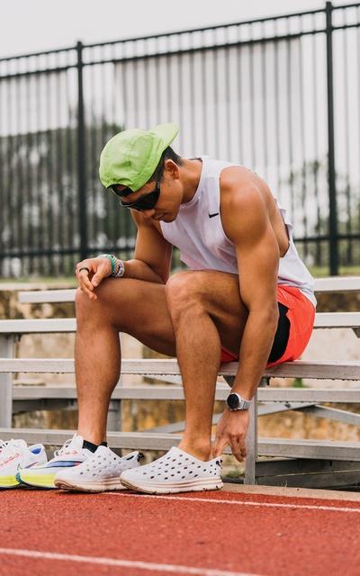A man wearing a pair of Kane slip-ons at a running track