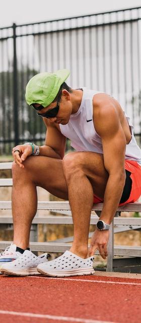 A man wearing a pair of Kane slip-ons at a running track