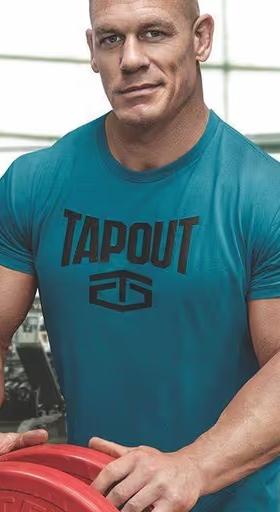 Jon Cena wearing a tapout shirt in aqua while weightlifting