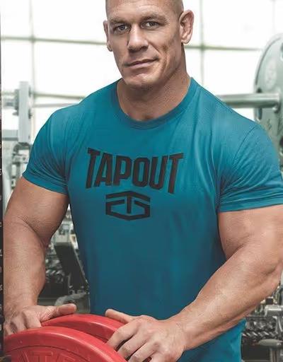 Jon Cena wearing a tapout shirt in aqua while weightlifting
