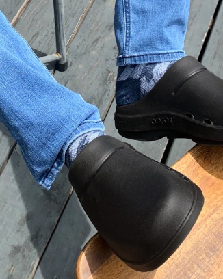 A man wearing a pair of Oofos slip-ons