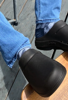 A man wearing a pair of Oofos slip-ons