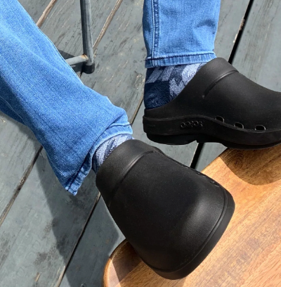 A man wearing a pair of Oofos slip-ons