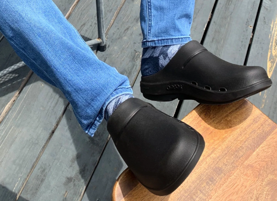 A man wearing a pair of Oofos slip-ons