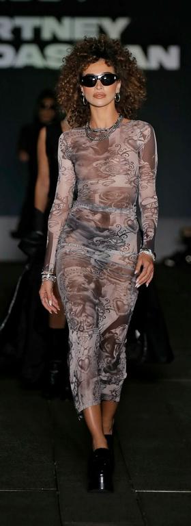 A woman walking the runway in a boohoo outfit and sunglasses