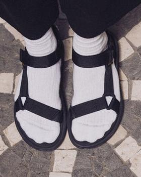 A person wearing a pair of Teva velcro sandals