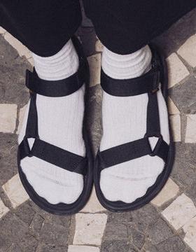 A person wearing a pair of Teva velcro sandals