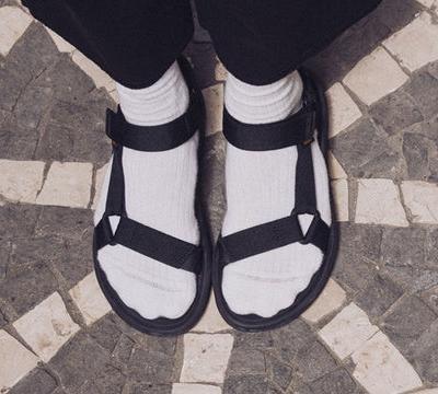 A person wearing a pair of Teva velcro sandals