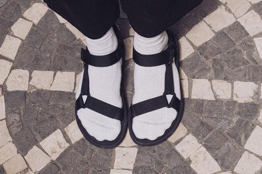 A person wearing a pair of Teva velcro sandals