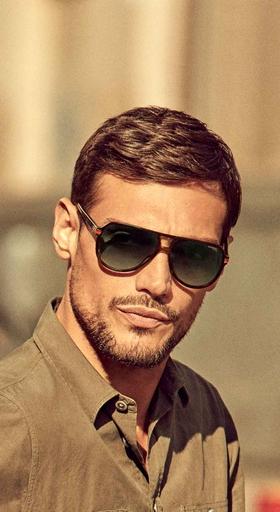 A man wearing a pair of black Carrera sunglasses
