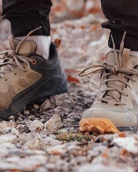 A man wearing a pair of brown and orange Oboz trail shoes