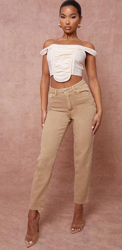 A woman wearing a PrettyLittleThing brown pants and white top