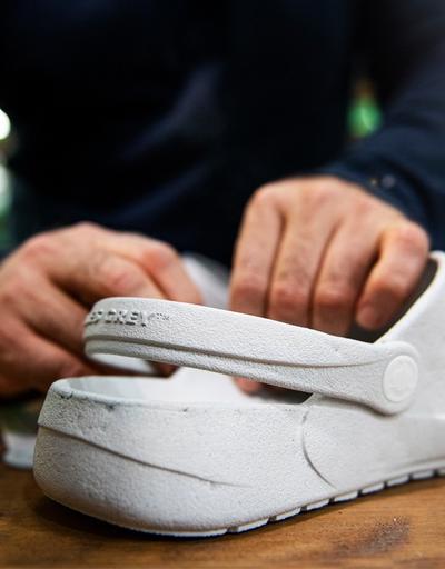 A man showcasing a pair of Ales grey slip-on shoes