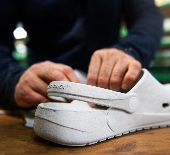 A man showcasing a pair of Ales grey slip-on shoes