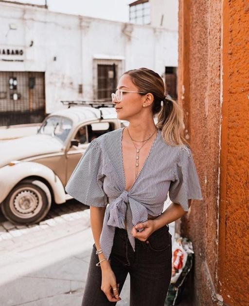 A woman wearing a Zaful blouse and outfit in grey