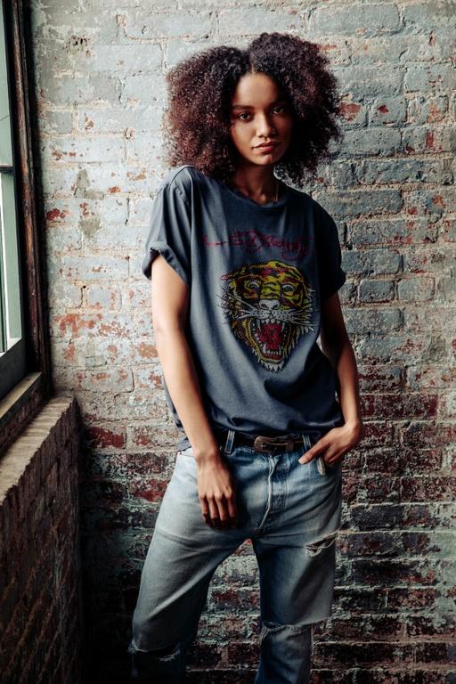 A woman wearing an Ed Hardy tattoo t-shirt in grey