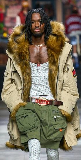 A man walking the runway wearing a Dsquared2 outfit with green shorts