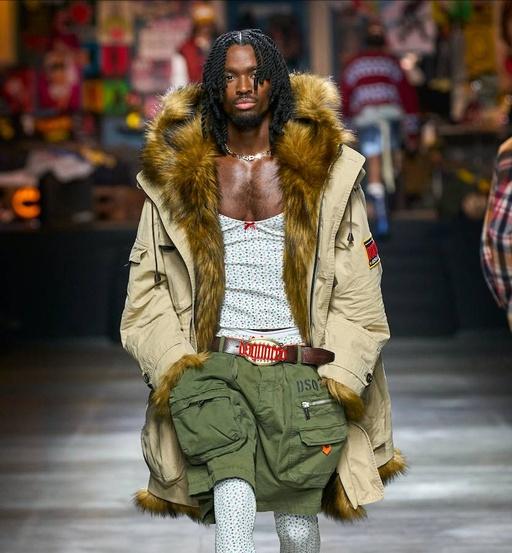 A man walking the runway wearing a Dsquared2 outfit with green shorts