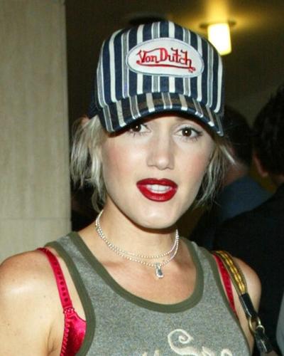 A woman wearing a striped von dutch trucker hat