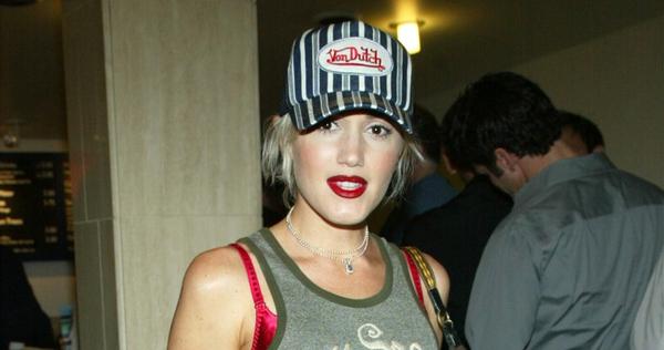 A woman wearing a striped von dutch trucker hat