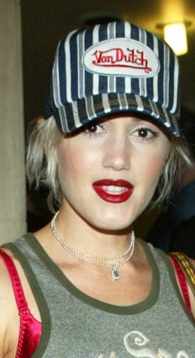 A woman wearing a striped von dutch trucker hat