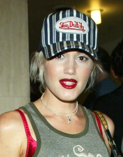 A woman wearing a striped von dutch trucker hat