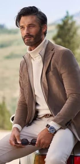 A man wearing a brown suit jacket and turtleneck
