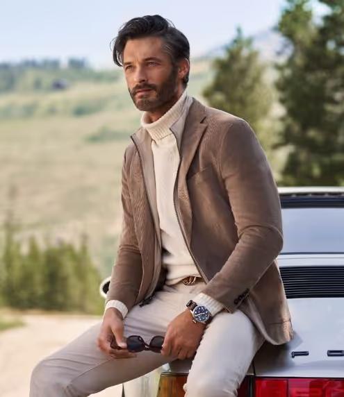 A man wearing a brown suit jacket and turtleneck