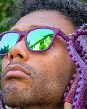 A man wearing Purple Goodr sunglasses