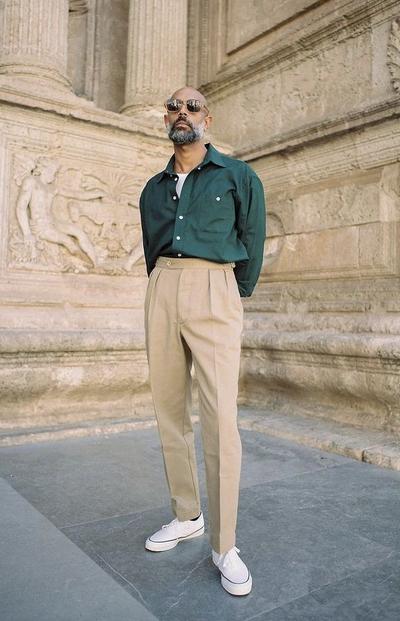 A man wearing a Shein green button up and khaki pants