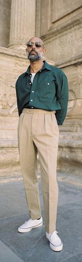 A man wearing a Shein green button up and khaki pants