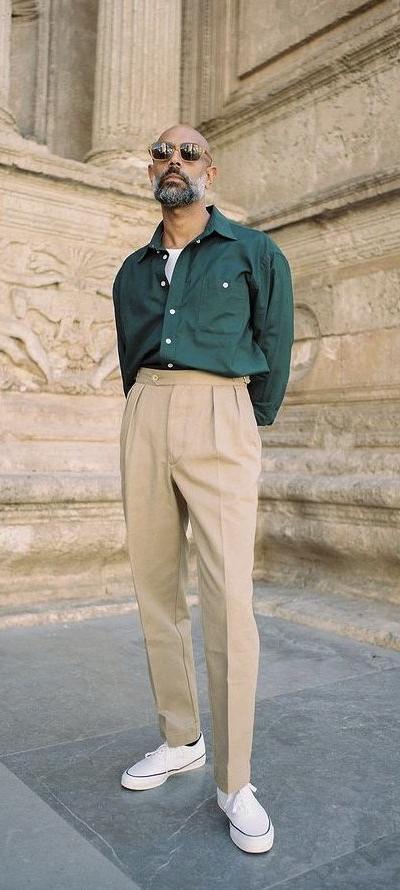 A man wearing a Shein green button up and khaki pants