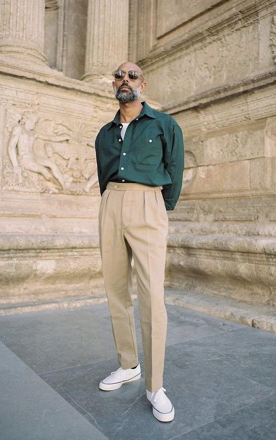 A man wearing a Shein green button up and khaki pants