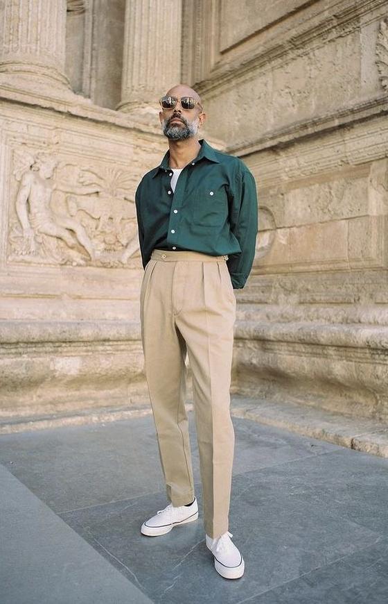 A man wearing a Shein green button up and khaki pants