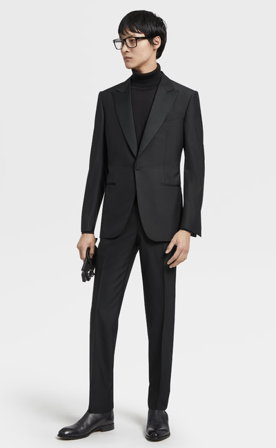 A man wearing an all black Zegna suit with a black turtleneck underneath