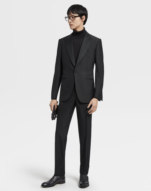 A man wearing an all black Zegna suit with a black turtleneck underneath