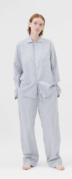 A woman wearing a Tekla pajama outfit in blue and white stripes