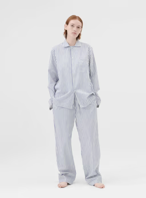 A woman wearing a Tekla pajama outfit in blue and white stripes