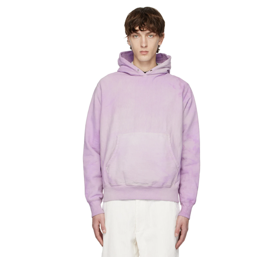 A man wearing a lavender Whim Golf hoodie with white pants