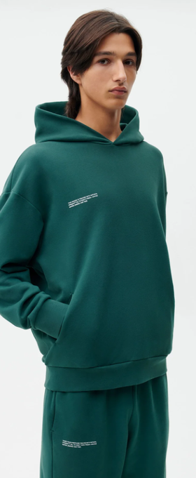 A man wearing a PANGAIA teal branded sweatsuit