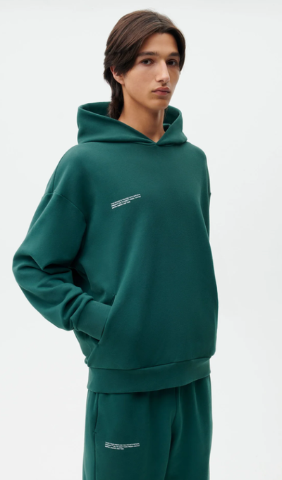 A man wearing a PANGAIA teal branded sweatsuit