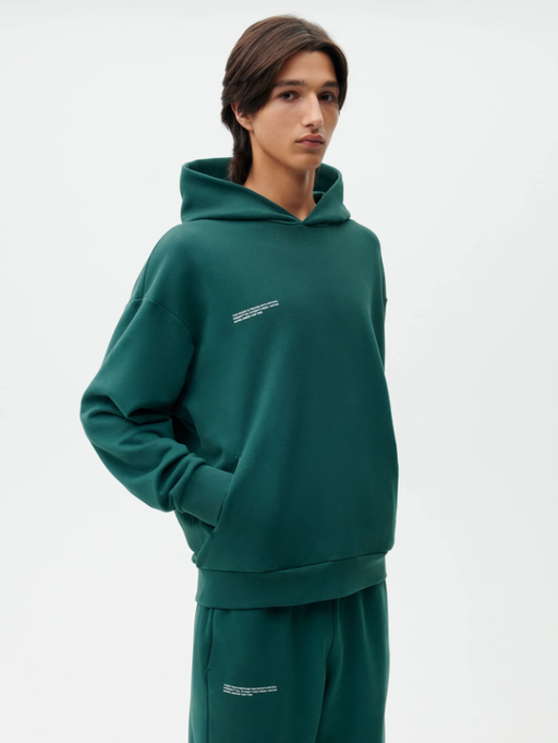 A man wearing a PANGAIA teal branded sweatsuit