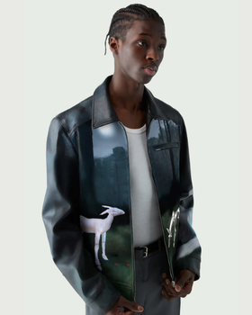A man wearing a Coperni leather jacket with deer images on it