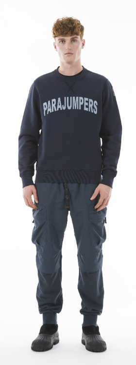 A man wearing a Parajumpers logo sweater and navy blue pants