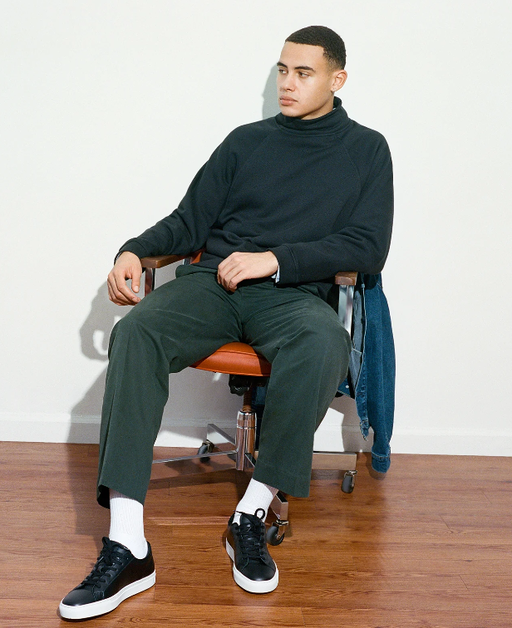 A man wearing a pair of Black Great Shoes with white soles